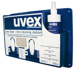 The Uvex Complete Cleaning Station is a wall-mounted unit in a blue and white colour scheme, featuring clear product labelling. It comes equipped with a spray bottle, tissues, and a mirror, making it ideal for cleaning and maintaining coated lenses. | Work & Wear DIrect