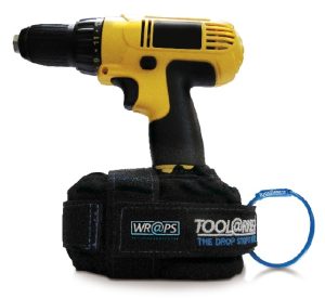 A yellow and black cordless drill is standing upright on a Tool Arrest Global Battery Wrap Tether with labels, with a blue wristband beside it. | Work & Wear DIrect