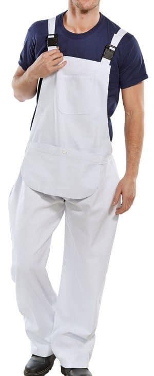 A person wearing a navy blue T-shirt and white dungarees, standing and holding one strap with their right hand. Their face is not visible. | Work & Wear DIrect